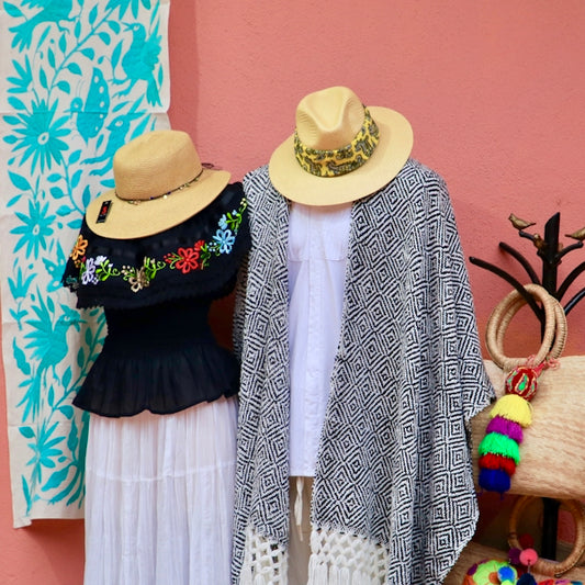 two women's hats are on display in front of a pink wall