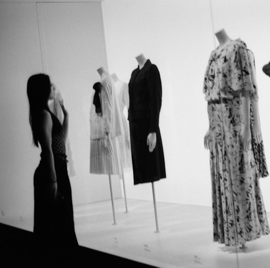A black and white photo of mannequins and dresses